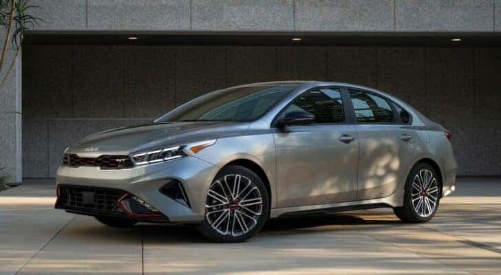 A silver 2023 Kia Forte GT is shown parked in a driveway after leaving a used Kia dealer.