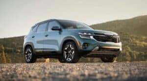 A blue 2024 Kia Seltos is parked on gravel after leaving a Kia dealer near Karns.