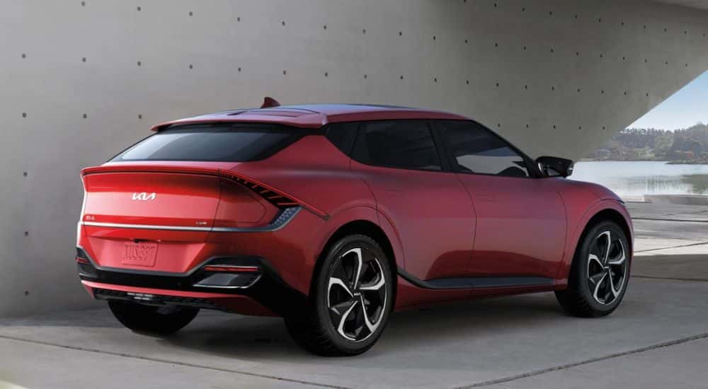 Rear view of a red 2025 Kia EV6 GT parked under a concrete structure.