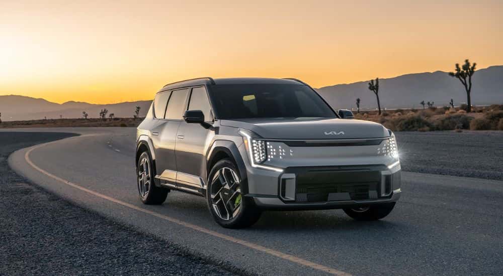 A silver 2026 Kia EV9 GT parked on an open desert road on the way to a Kia dealer near Karns.