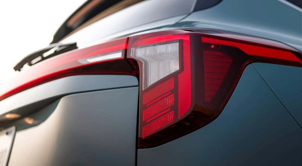 A blue 2025 Kia Seltos is shown from the rear in close-up.