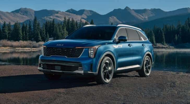 A blue 2024 Kia Sorento for sale near Oak Ridge is shown near a lake.