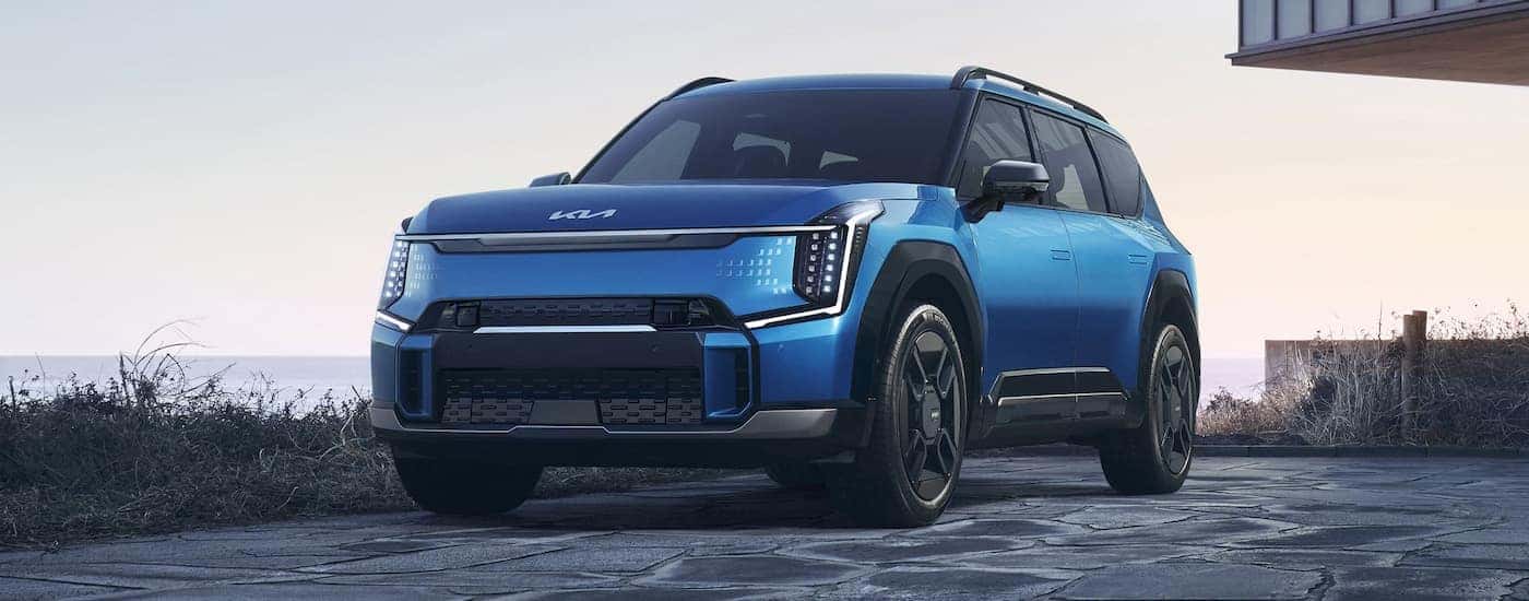 A blue 2025 Kia EV9 is shown from the front at an angle.