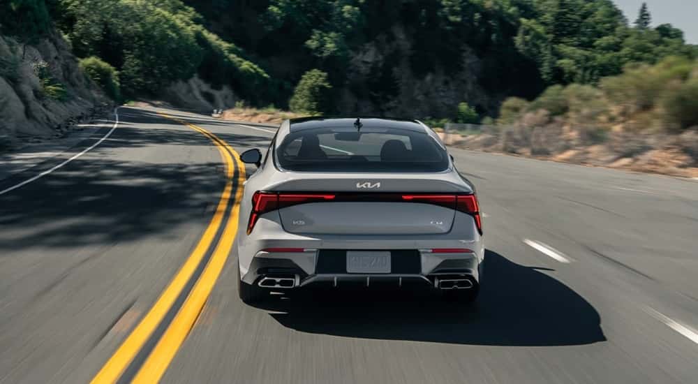 A grey 2025 Kia K5 from the rear.