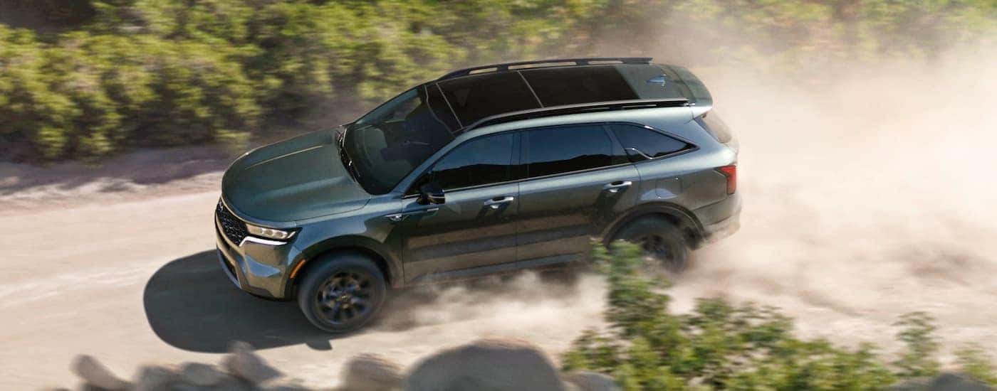 A dark green 2022 Kia Sorento X-Line for sale near Farragut driving down a dirt road.