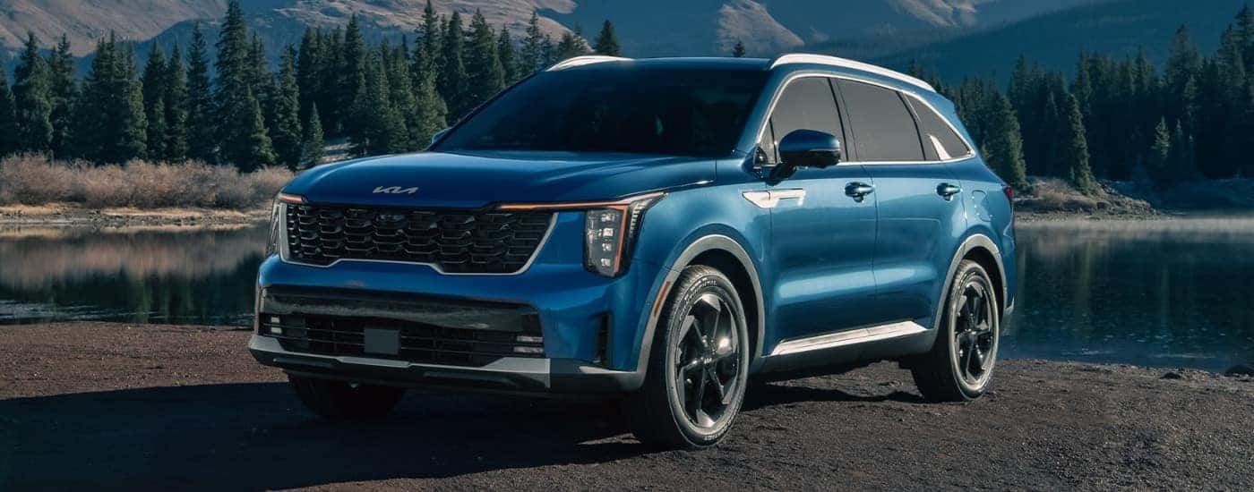 A blue 2024 Kia Sorento for sale near Oak Ridge is shown near a lake.