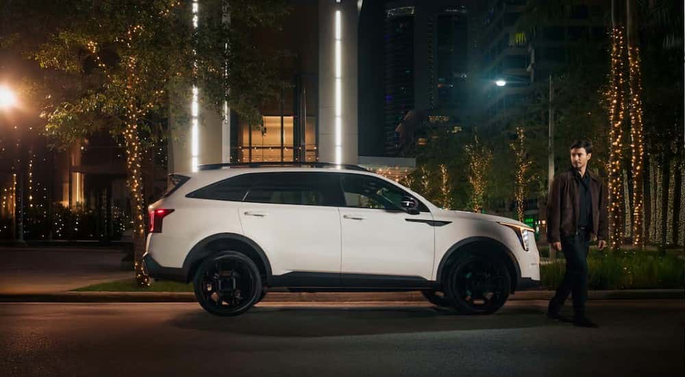 A white 2025 Kia Sorento S parked in a city.
