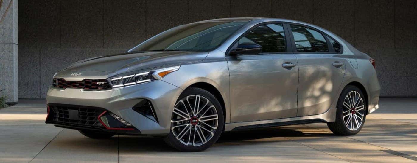 A silver 2023 Kia Forte GT is shown parked in a driveway after leaving a used Kia dealer.
