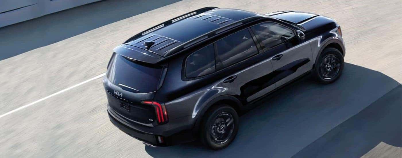 A black 2024 Kia Telluride driving down the street