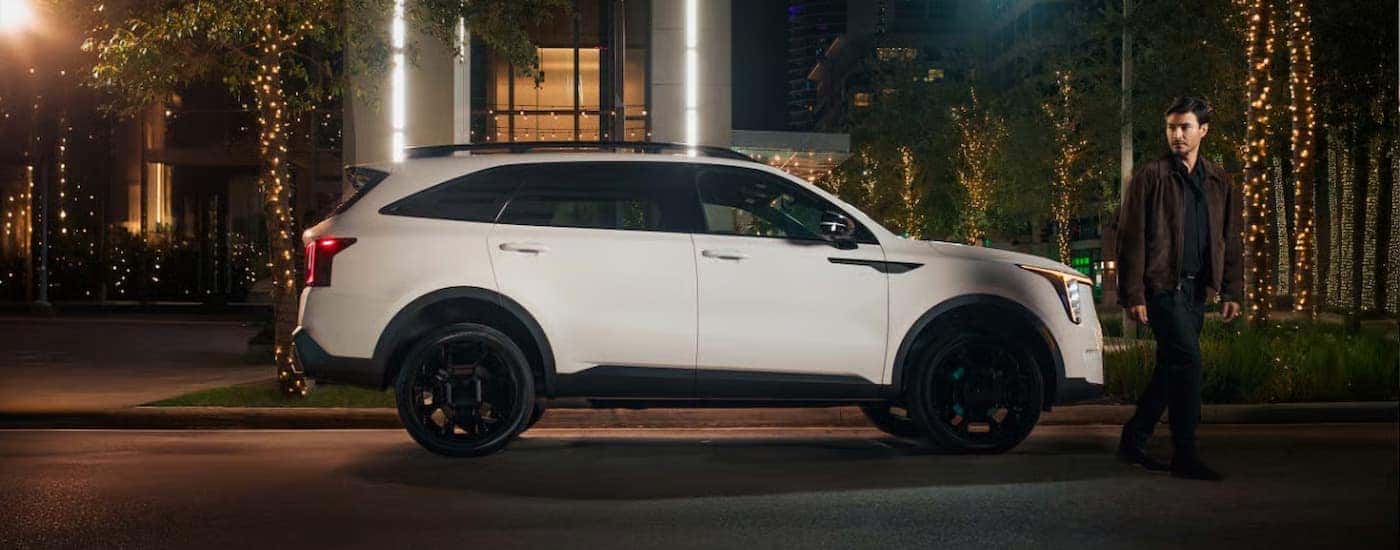 A white 2025 Kia Sorento parked in a city at night