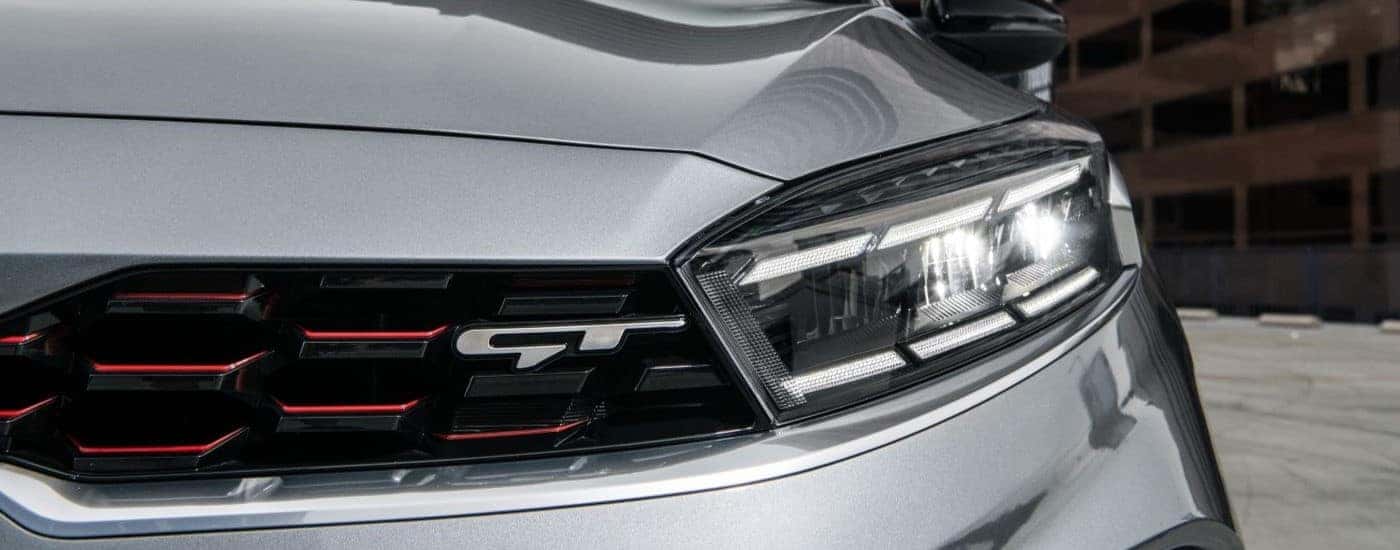 Close-up on the headlight of a grey 2023 Kia Forte GT after visiting a Kia dealer near Sevierville.