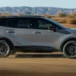 A gray 2026 Kia Sportage X-Pro is driving fast off-road.