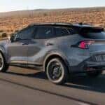 A gray 2025 Kia Sportage driving down a highway