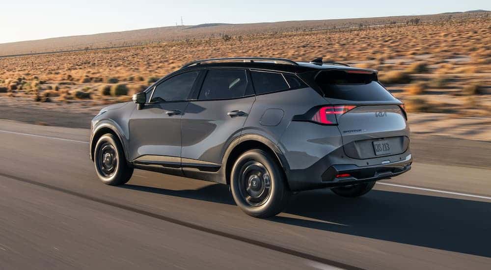 A gray 2025 Kia Sportage driving down a highway