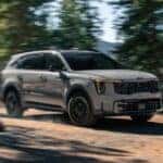 A gray 2025 Kia Sorento driving off-road on a trail