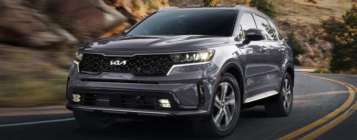 Grey 2025 Kia Sorento Hybrid driving around a bend.