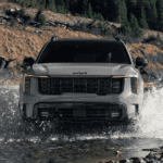 Grey 2026 Kia Sorento driving through a creek