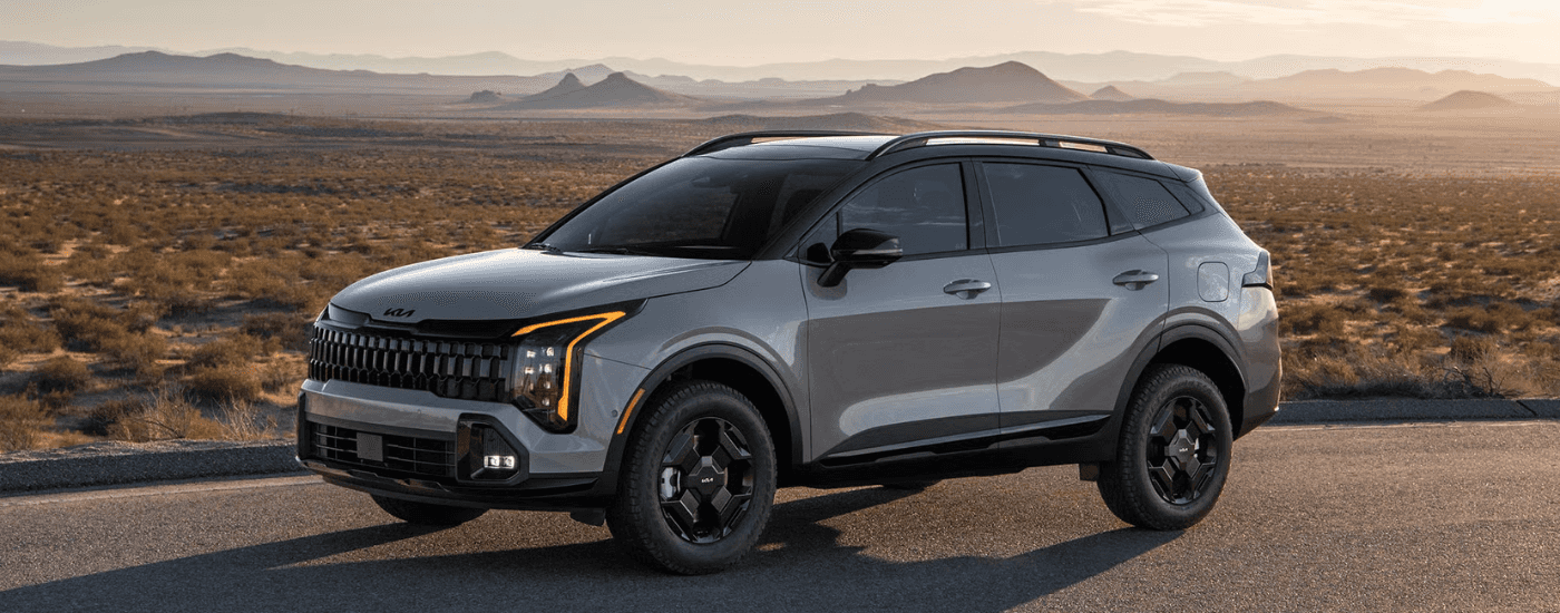 Silver 2026 Kia Sportage parked in front of a arid landscape
