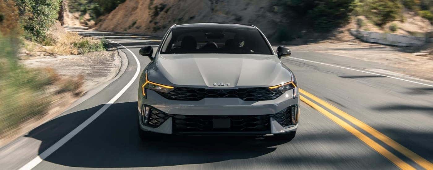 A grey 2025 Kia K5 from the front.