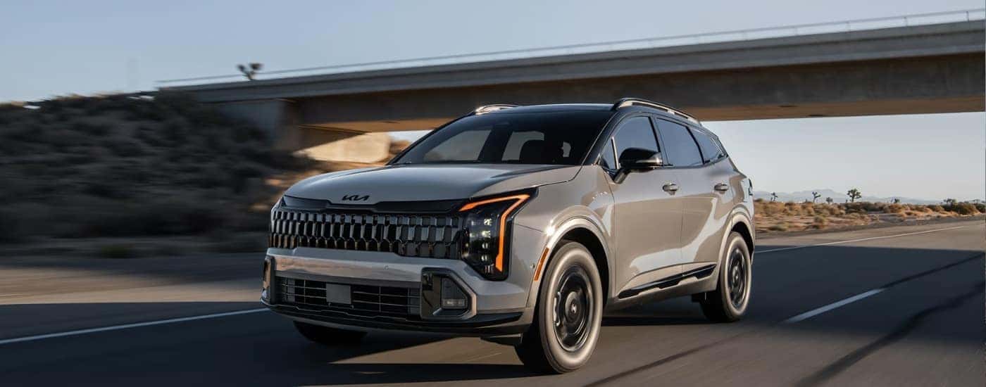 A grey 2026 Kia Sportage Hybrid from the front.