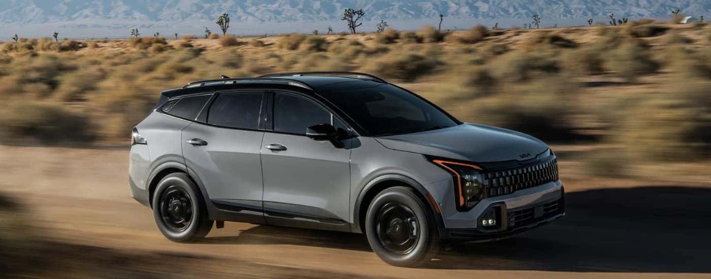 A grey 2026 Kia Sportage Hybrid for sale from the side.