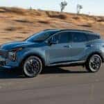 A gray 2026 Kia Sportage Hybrid driving on a highway.