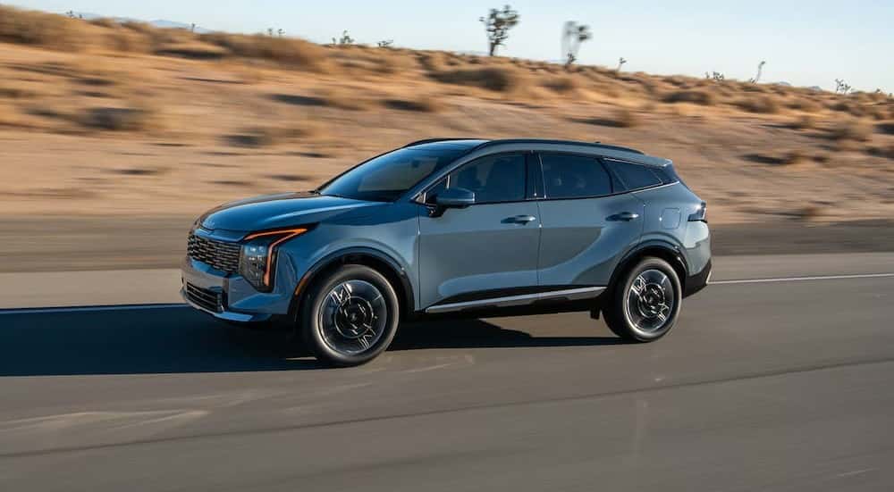 A gray 2026 Kia Sportage Hybrid driving on a highway.