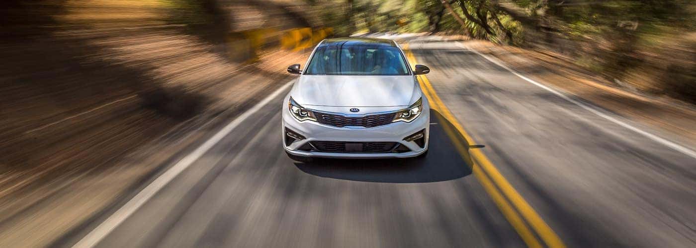 White 2020 Kia Optima driving to a Kia dealer near Maynardville
