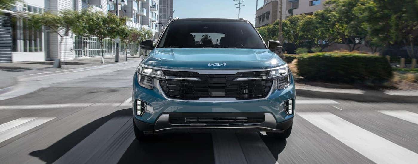 A blue 2026 Kia Seltos driving in a city