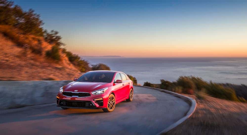 Red 2020 Kia Forte driving along the coast