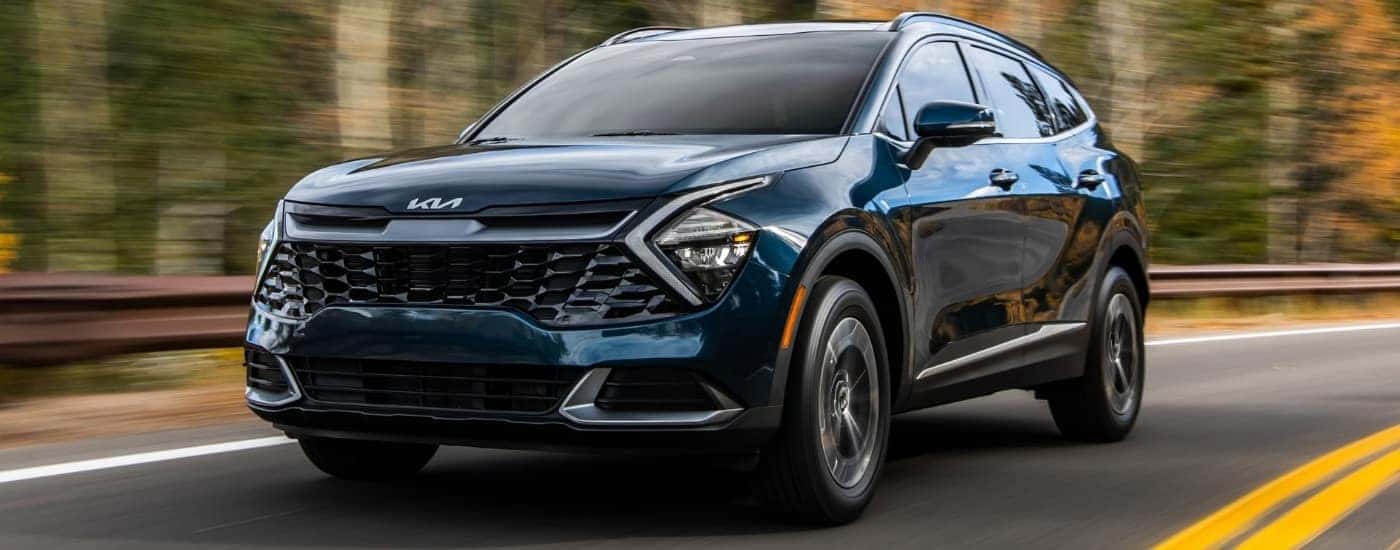 Blue 2023 Kia Sportage Hybrid for sale near Oliver Springs driving on a highway