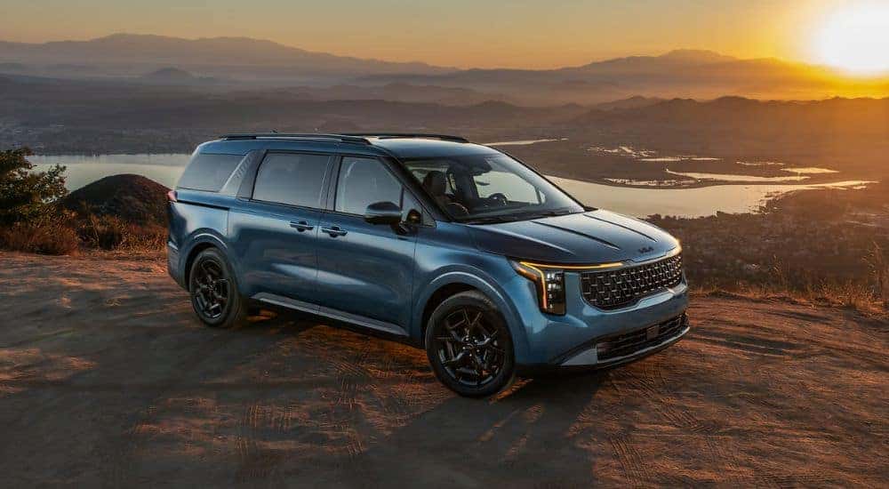 Blue 2026 Kia Carnival parked on top of a mountain