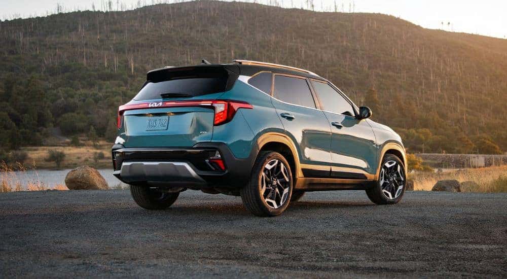 Blue 2026 Kia Seltos rear view parked near a lake at sunset