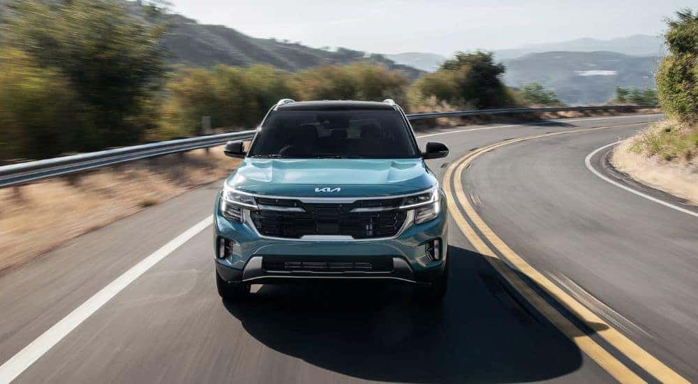Blue 2026 Kia Seltos driving on a curvy road