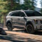 Grey 2026 Kia Sorento driving in the woods