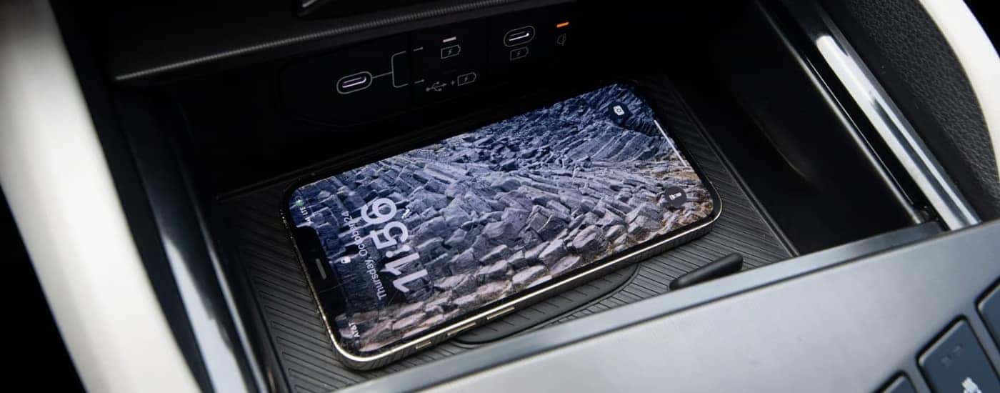 Smart phone in the center console of a 2026 Kia Sportage HEV