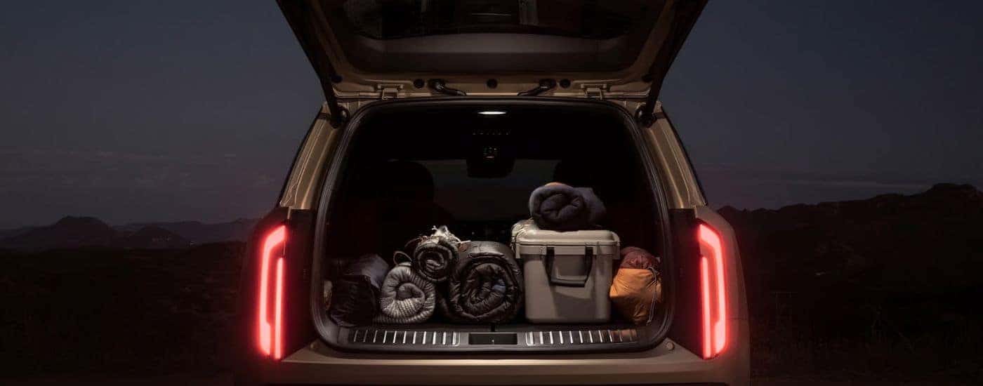 2027 Kia Telluride X-Pro SX Prestige with liftgate lamp open to reveal camping gear.