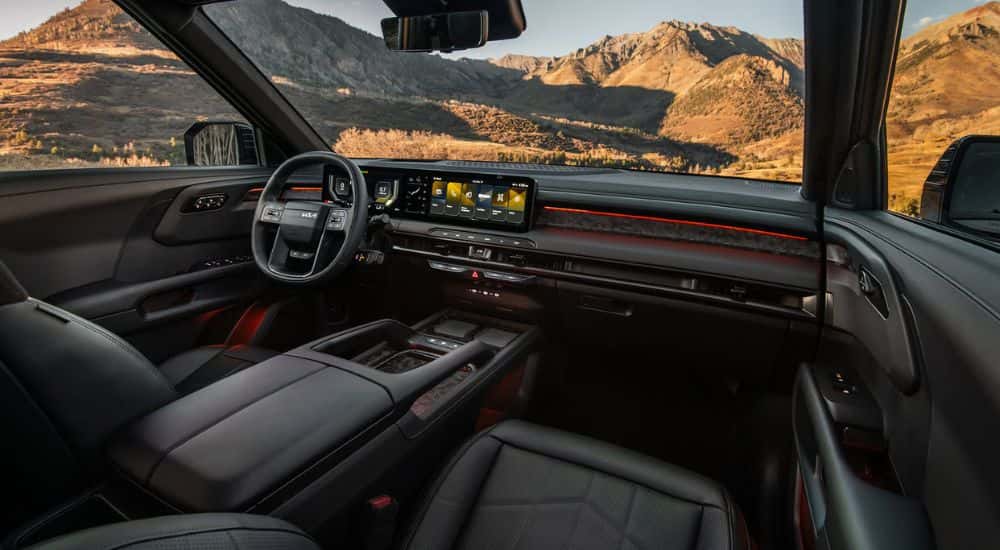 Interior view of a 2027 Kia Telluride infotainment and steering wheel parked by mountains.