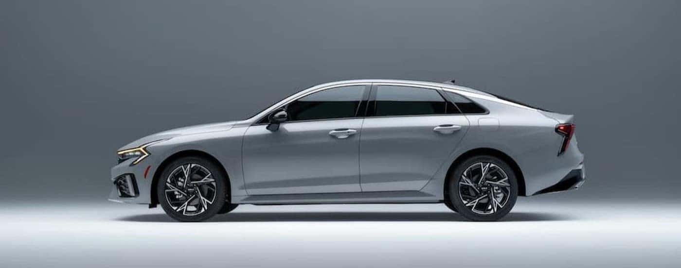 A silver 2026 Kia K5 parked in a gray room.