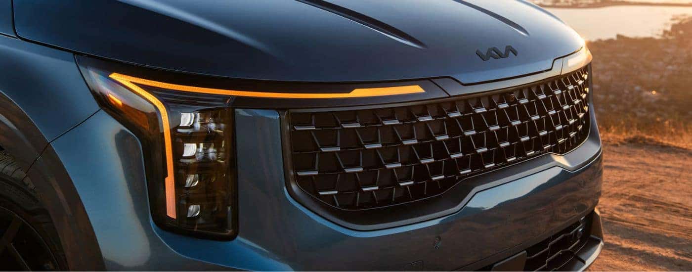 Front grille view of a blue 2027 Kia Carnival SX Prestige.