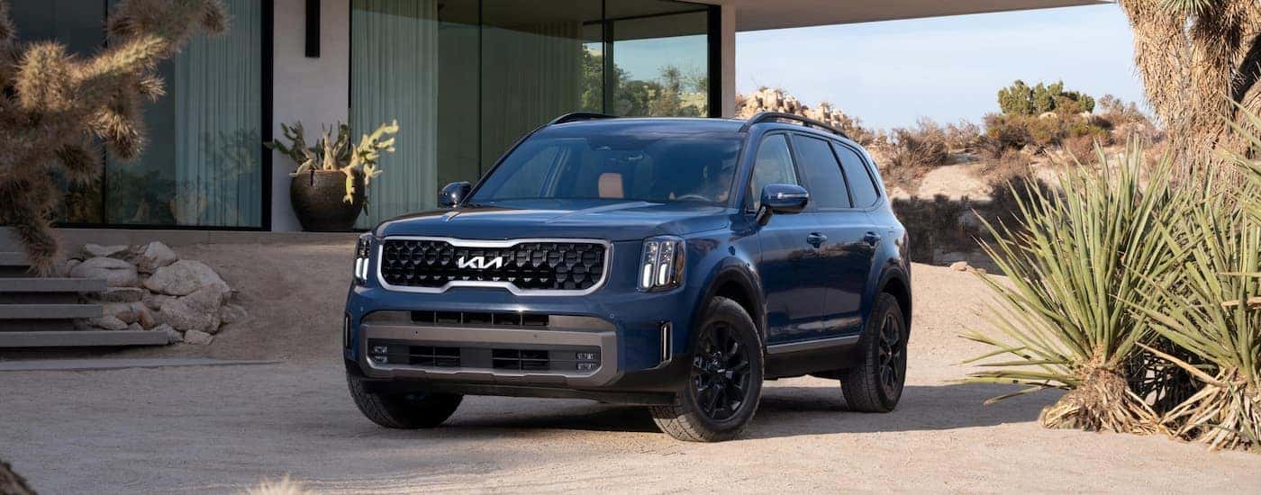 A blue 2023 Kia Telluride parked on a driveway.