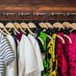 An organized, color-coded closet starting with white shirts, then green, then red.