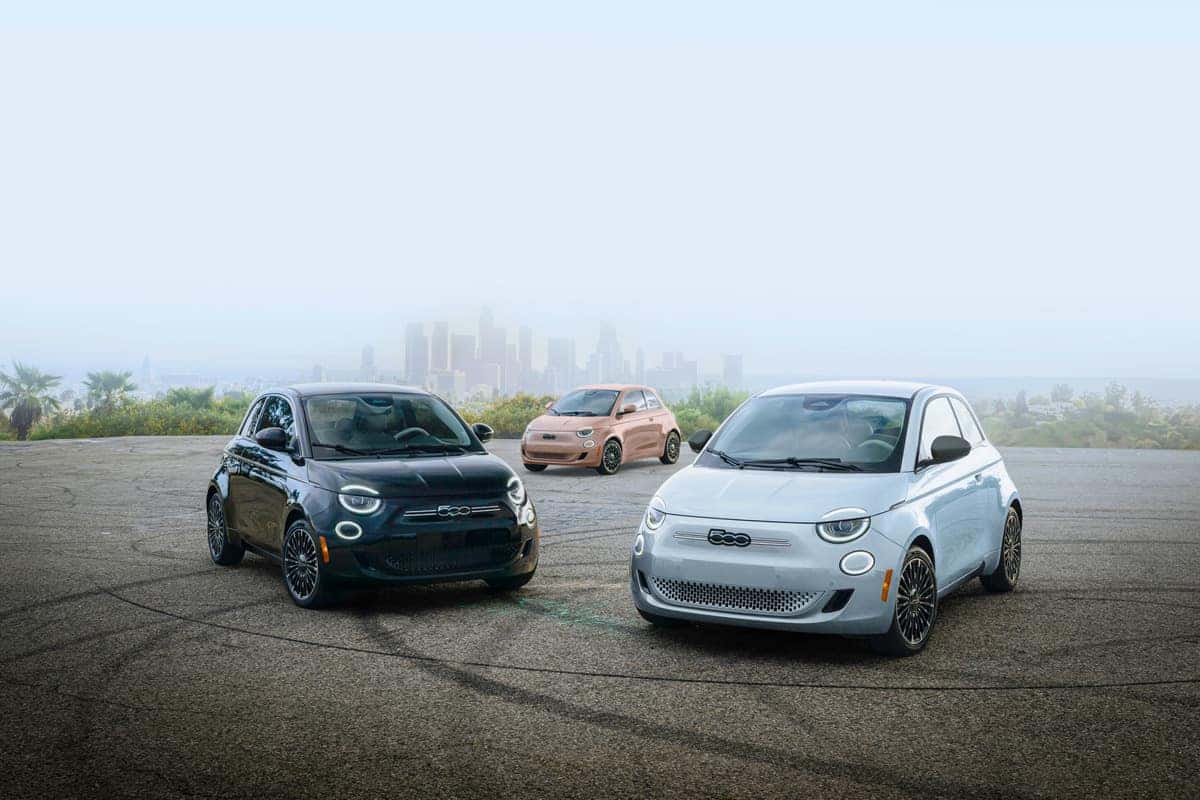 Three 2024 Fiat 500e models parked in a lot, showcasing modern eco-friendly vehicles in a clean, organized space.