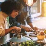 Couple Cooking Together. Standing around the kitchen island, having fun and preparing food together
