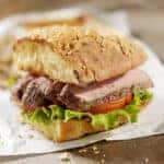 Steak sandwich on French bread with lettuce and tomato