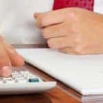 Man in suit working on calculator