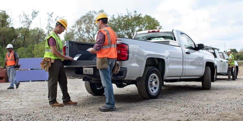 Construction workers stand at 2018 Chevrolet Silverado 1500 truckbed