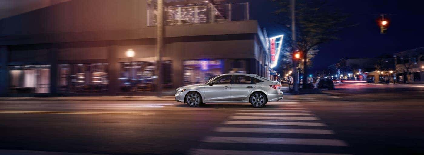 A white Honda Civic running in the city