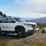 White 2019 Honda Passport AWD in front of lake towing ATV
