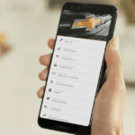 A white hand holding a smartphone with the Chevrolet Connected Services App pulled up.